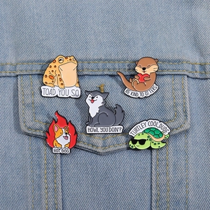 Detailed close-up of cartoon animal enamel pins pinned to a light blue denim jacket pocket