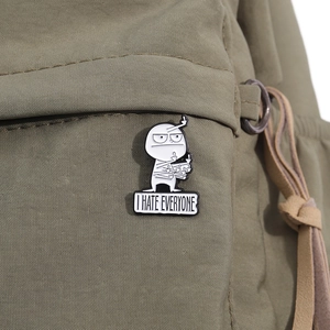 Detail of I HATE EVERYONE enamel pin showing cartoon figure on an olive canvas bag