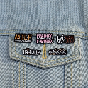 Detail of five colorful Friday themed enamel pins on a light blue denim jacket pocket