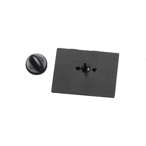Detail view of the matte black metal brooch back with secure pin and rubber clutch cap