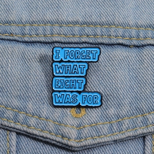 Macro d'un pin's en émail bleu avec texte sur une veste en jean pour accessoire