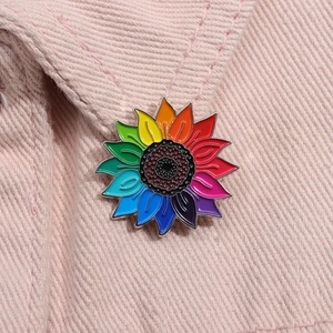 Broche tournesol artistique arc-en-ciel en émail avec pétales colorés sur denim