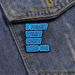 Vue détaillée du pin's en émail bleu ciel avec texte sur fond en denim bleu
