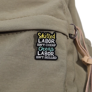 Detail der Skilled Labor Emaille-Anstecknadel auf grünem Canvas-Taschenhintergrund