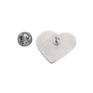 Vista dettagliata del retro della spilla a cuore con trama in metallo argento e chiusura a farfalla
