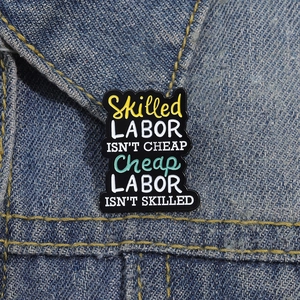Emaille-Anstecknadel mit buntem Schriftzug auf einer Jeansjacke für modischen Akzent
