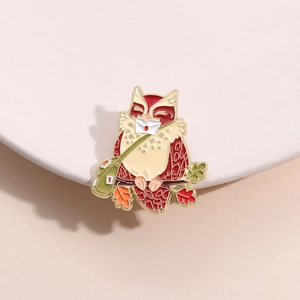 Détail du pin's hibou messager avec feuilles d'automne sur un socle blanc rond