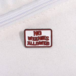 Macro shot of rectangular enamel brooch with red No Weenies Allowed text on canvas