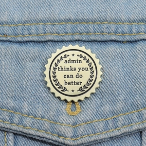 Detail of a gold motivational badge with black engraving on light blue denim jacket