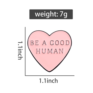Pink heart enamel pin featuring BE A GOOD HUMAN text detail and 1.1 inch dimensions