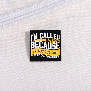 Detail of square black enamel pin badge with father humor text on white canvas background