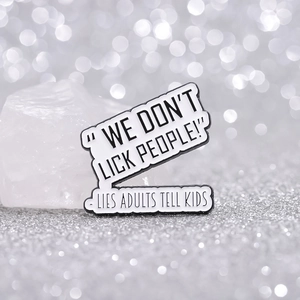 Enamel pin with black and white humor quote resting on white crystal stone background