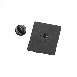 Vue macro du dos du pin's montrant la surface en métal noir texturé et l'embout en gomme