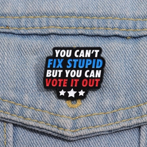 Enamel pin with You Can't Fix Stupid message on denim jacket in American retro style