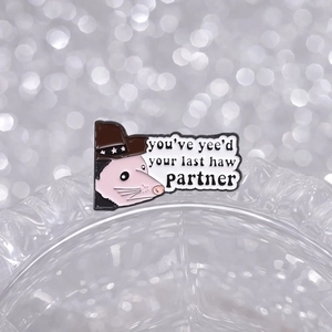 Cute enamel opossum pin wearing a cowboy hat with funny yee-haw quote on glass edge