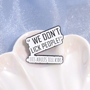 Enamel pin badge with 'WE DON'T LICK PEOPLE' quote on a decorative white shell tray