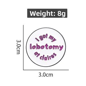 Funny white enamel badge with pink lettering I Got My Lobotomy At Claire's, 3cm diameter