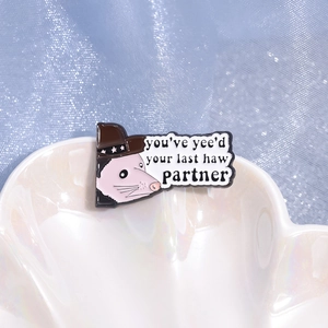 Cowboy opossum enamel pin with You've yee'd your last haw partner text on shell plate