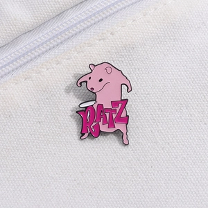 Macro view of a pink cartoon rat enamel pin with RATZ text on white canvas background