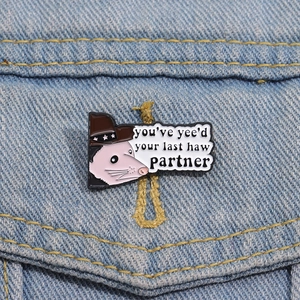 Funny cowboy opossum enamel pin featuring 'you've yee'd your last haw' text on denim jacket
