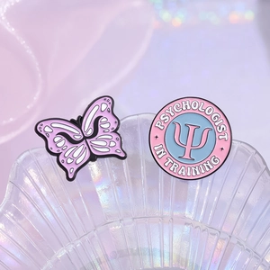 Pink and purple enamel brooch set featuring a butterfly and Psychologist In Training design