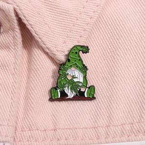 Détail d'un badge nain en émail avec feuilles vertes sur le revers d'une veste rose