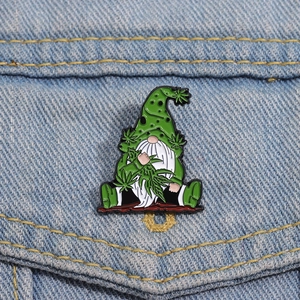 Pin's gnome en émail avec feuille verte et barbe blanche sur une veste en jean