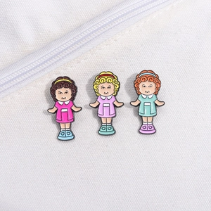 Three cute cartoon girls enamel pins in various colors on a white canvas bag