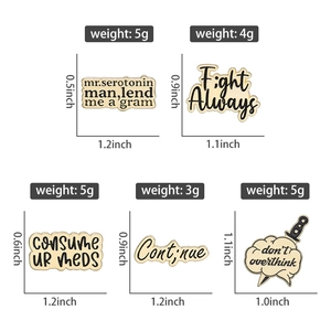 Detail view of vintage enamel pins set with text slogans, weights, and dimensions
