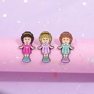 Three cute cartoon girls enamel pins with curly hair in pink, purple, and cyan dresses