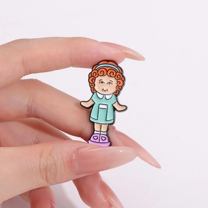 Cartoon enamel pin featuring a girl with orange curly hair and green dress in hand