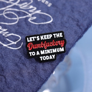 Schwarze Emaille-Anstecknadel mit dem Spruch 'LET'S KEEP THE Dumbfuckery TO A MINIMUM TODAY'