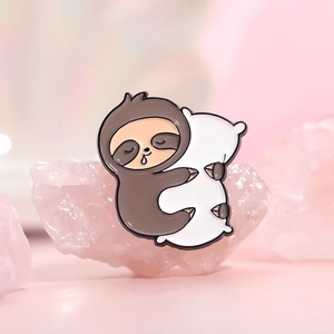 Cute sloth hugging white pillow enamel pin with pink crystal stone background