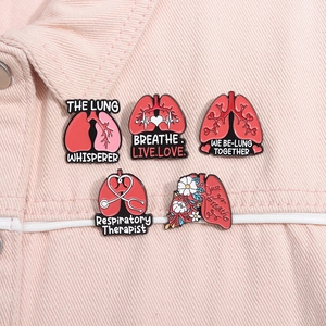 Detailed enamel pins featuring lung anatomy and medical quotes on a pink denim jacket