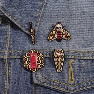 Detail of horror movie pins showing Overlook carpet pattern and Room 237 on denim