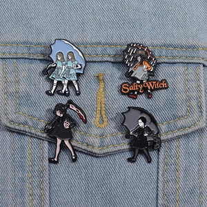 Detail von vier dunklen Emaille-Pins inklusive Salty Witch an einer Denim-Jacke