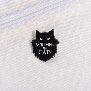 Détail du pin's en émail noir Mother of Cats sur une texture de sac en toile