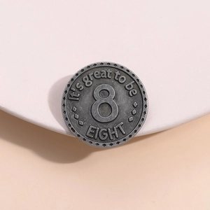 Distintivo retrò in metallo argentato con numero 8 inciso su espositore rosa chiaro