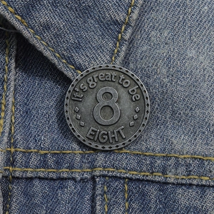 Dettaglio macro della spilla in metallo retrò numero 8 su sfondo in tessuto denim