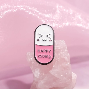 Creative pill capsule enamel pin with happy face and pink macaron color styling