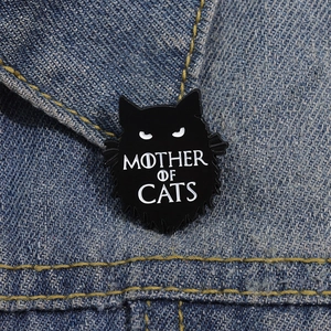 Détail d'un pin's chat noir émaillé avec texte Mother of Cats sur tissu en jean