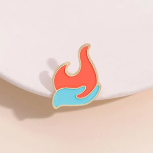 Minimalistische Emaille-Brosche mit Flammen-Element in kreativem Orange-Blau-Design