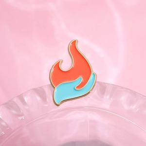 Künstlerische Emaille-Brosche in Flammenform mit blauem Hand-Design auf rosa Grund