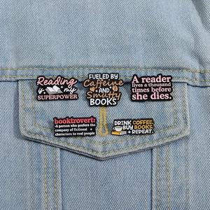Lot de 5 pin's en émail café et livres épinglés sur une veste en jean bleu clair