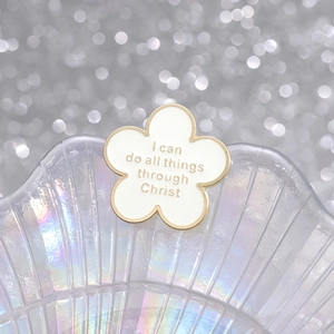 Broche fleur blanche en émail avec bordure dorée et citation sur plateau irisant