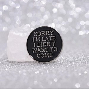 Broche en émail noir avec texte humoristique et design géométrique minimaliste