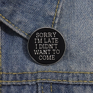 Broche en émail noir avec slogan Sorry I'm Late sur le col d'une veste en jean