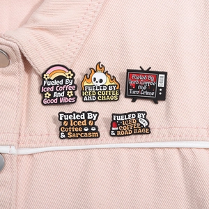 Detail of five coffee-themed enamel pins pinned on a pink denim jacket pocket