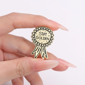 Stay Golden enamel medal brooch in gold finish with ribbon design for accessories