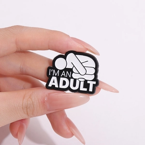 Broche créative avec figurine blanche et texte I'M AN ADULT sur fond en émail noir